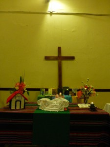 la mesa de comunión: flores, la casita, pan y vino. Atrás las Biblias de hermanos y hermans de la iglesia en homenaje por el día de la Biblia